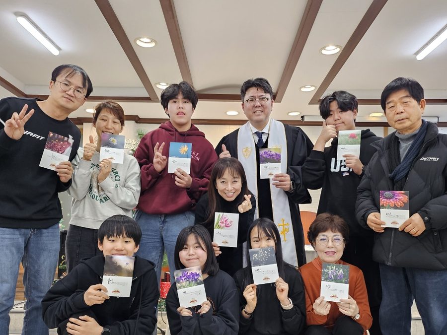 책자를 들고 함께 선 성도들