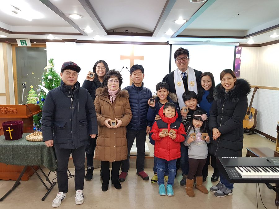 십자가 앞에 나란히 선 가족들